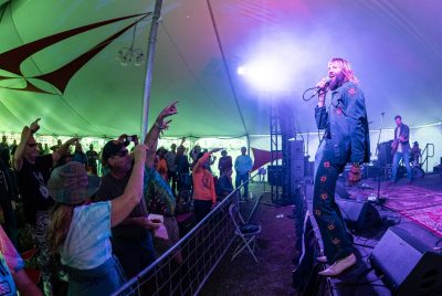 Paul McDonald stands on stage with a microphone, singing to a live audience