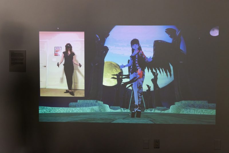 Projection of student using virtual reality software to move artwork.